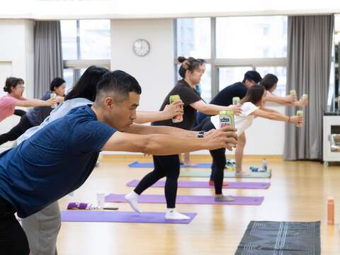 拿著啤酒瓶結合瑜伽動作延展身體。(圖片來源：臺北市政府青年局)