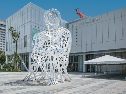 建築巡禮-1 美術館的白色立方體建築與光影交織的鏤空人形雕塑相互映襯。