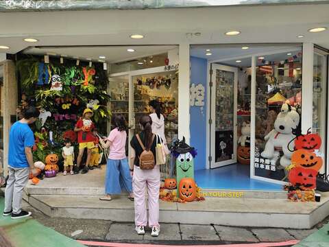 變裝親子於店家萬聖節打卡牆開心留影紀念（圖片來源：臺北市商業處）