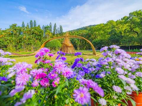 以原木和竹子交融打造的「風起光瀾」與花海交織呈現逐夢旅程的韌性與希望(圖片來源:臺北市政府工務局公園路燈工程管理處)