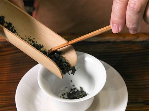 取出適量茶葉放入蓋杯中。（攝影／鄒瑋）