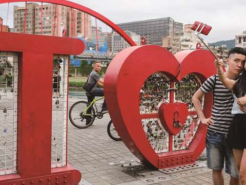 成美河濱公園的LOVE裝置藝術上掛了許多愛情鎖。（攝影／楊智仁）