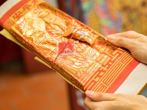 先向廟方領取祭拜用的金紙。（攝影／梁忠賢）