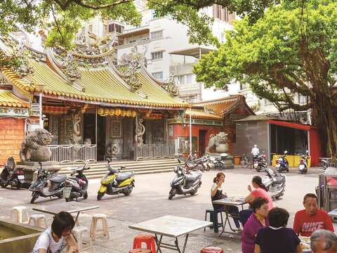 慈聖宮廟埕前擺上數張桌椅,形成共同用餐區。(攝影╱高讚賢)