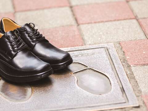 鑲嵌在地上的鞋印銅版磚，呈現沅陵街的在地特色。（攝影／梁忠賢）