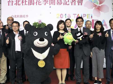 2018台北杜鵑花季盛大開幕，台北市政府副秘書長李文英（前排左5）率領熊讚、觀傳局長陳思宇（前排右4）、公園處長黃立遠（前排左3）、市府顧問謝豐舟（前排左2）、與來自日本福岡縣久留米市大久保勉市長（前排右5）、今年杜鵑花季主視覺設計師蕭青陽（前排左1），在開幕記者會後合影。