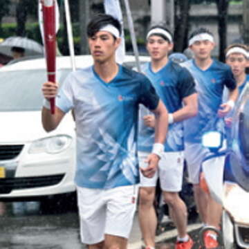 短跑新秀楊俊瀚冒雨完成接棒。