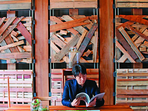 Home Hotel大安館1樓展區牆面設計，使用回收的木棧道，是文青拍照優選地。（攝影／蔡敏姿）