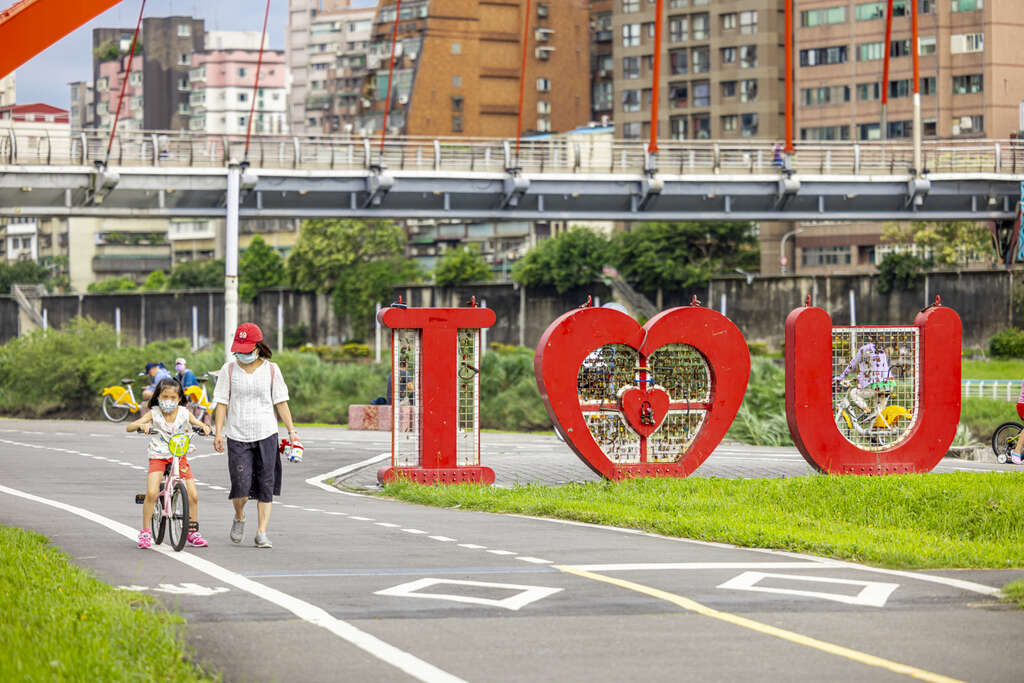 家长带着孩子骑乘自行车，享受亲子间的快乐时光(图片来源：台北市政府观光传播局)