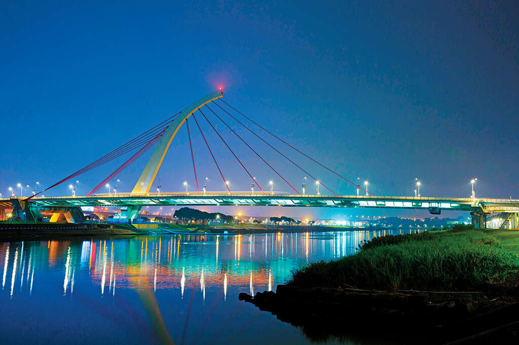 夜晚途经基隆河岸，可见大直桥灯光映照水面的美景。