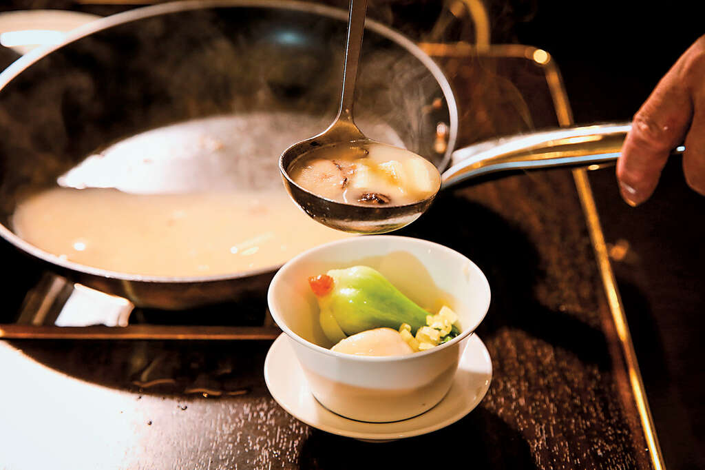 將鹹湯倒入碗，搭配著鹹元宵與青江菜一起吃。（攝影／林俊耀）