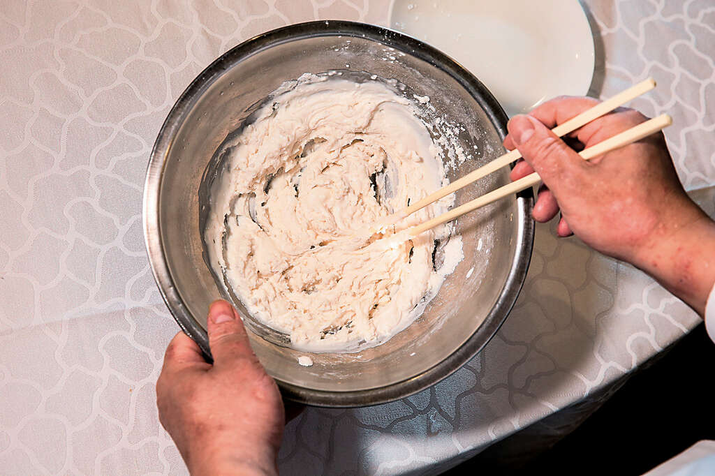 Step1將糯米粉倒入盆中，加入些許清水，用筷子拌勻至糯米粉結塊後，再用手搓揉，可避免手沾附過多粉漿。（攝影／林俊耀）