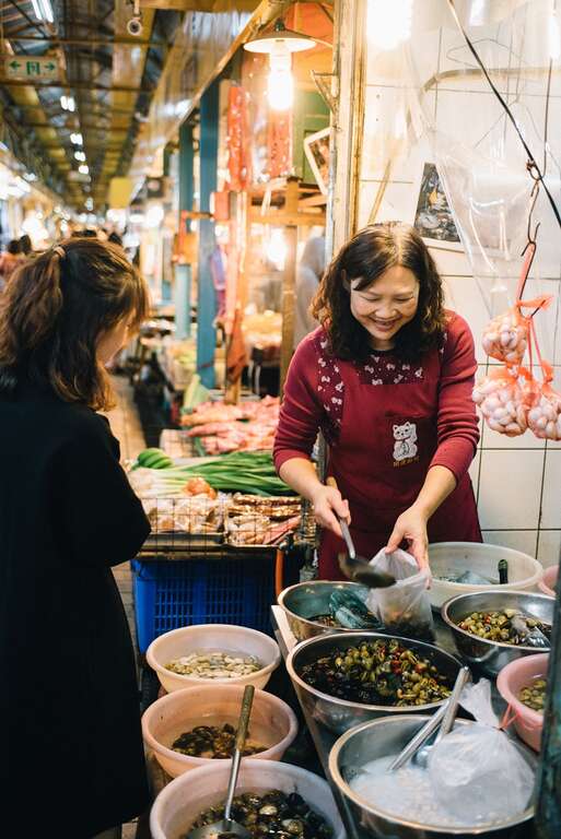1.賣醃蜆仔的老闆娘，笑容可掬地和客人分享獨家配方。