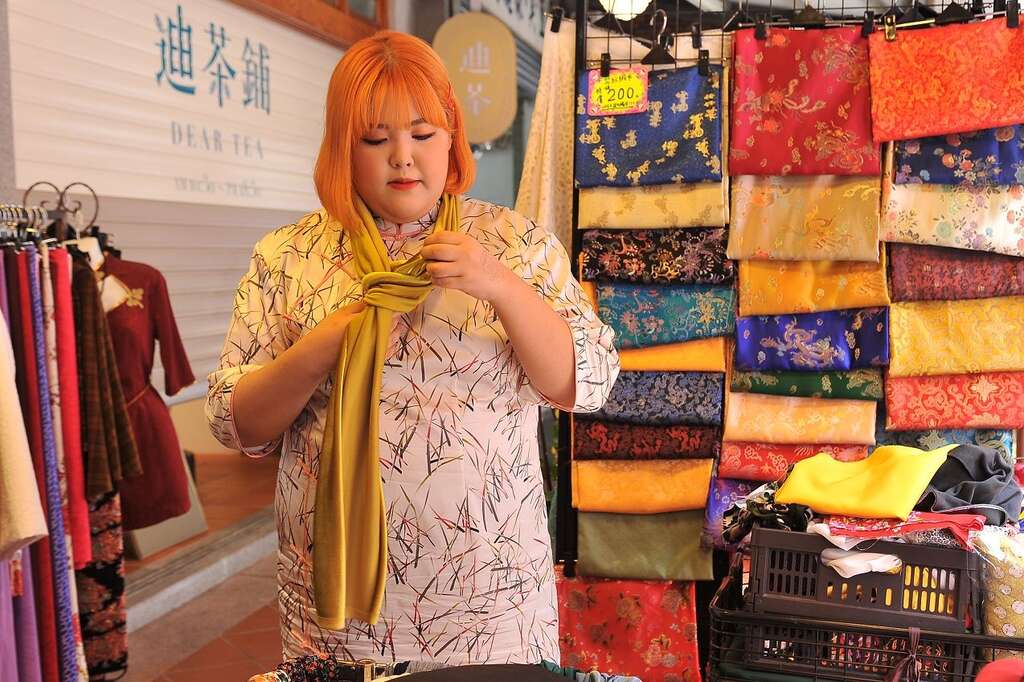 梁粹斌在台北市迪化街挑选旗袍布料