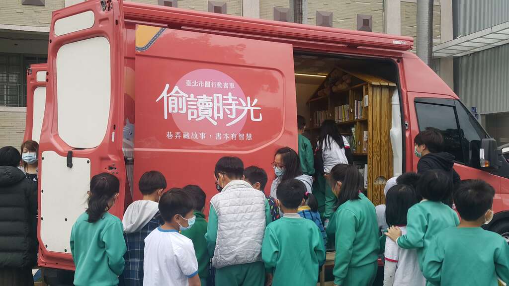 「行动书车前进校园场次」─小朋友围在书车旁挑选图书，对阅读的热忱一览无遗