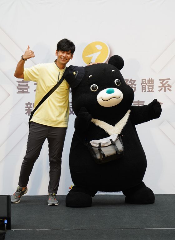 杨子仪与熊赞背上侧背包，扮演走动式旅游服务人员