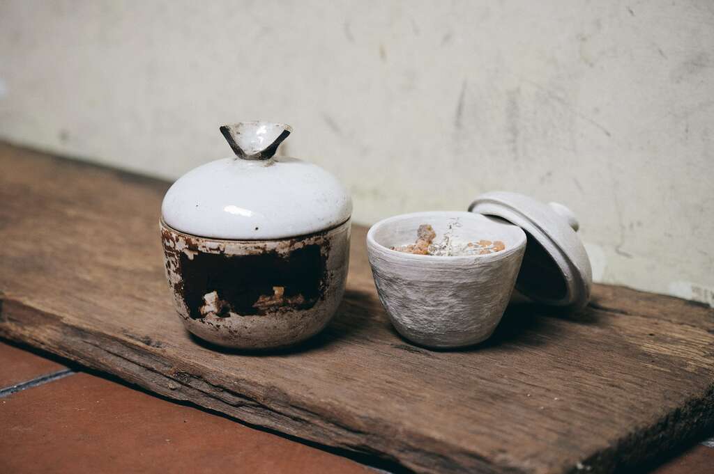 「地衣荒物」的熱賣商品「中藥陶罐蠟燭」（右），造型靈感來自傳統中藥罐（左）。（攝影／陳冠凱）