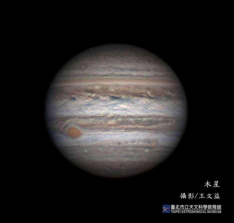 表面充满斑斓带纹的木星。左下角即着名的大红斑，直径可达数万公里，为一类似台风的巨大气旋风暴。