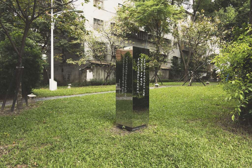 纪州庵文学森林的户外空间，手写字艺术家「今晚我是手」在镜面书柜写下房慧真〈百花深处〉段落，让文字浇灌心灵的意象与书柜相对应。
