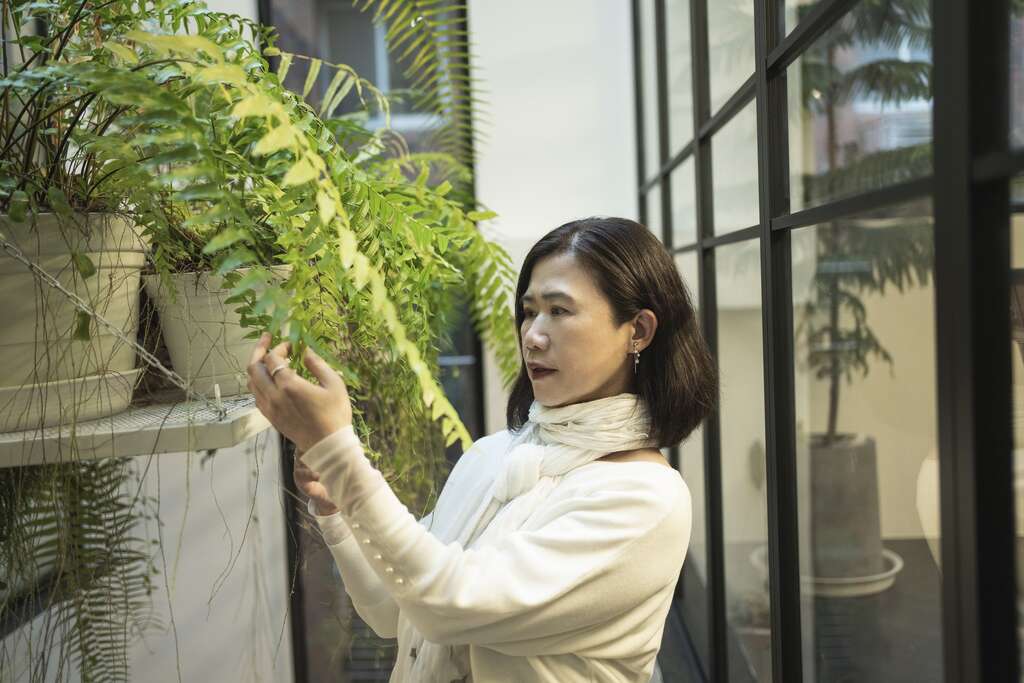 观赏美丽的植物能让彭树君心情舒畅，激发书写灵感。(摄影／陈志诚)
