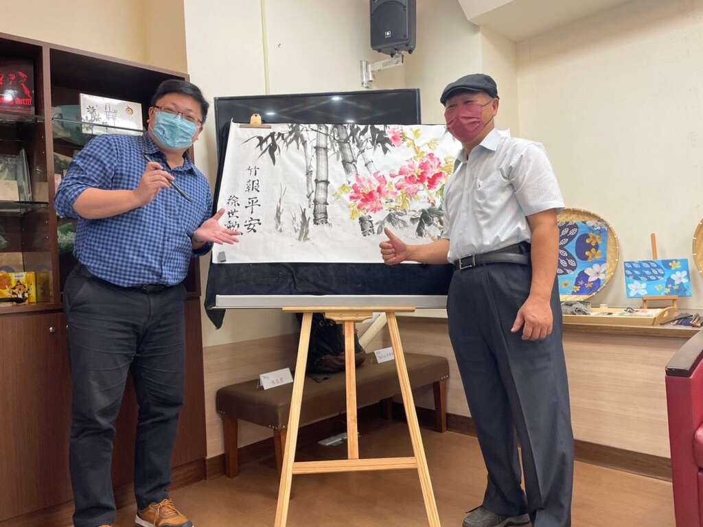 成果發表會開幕演出由北市客委會主委徐世勲在畫作上題字寓意平安(圖片來源：臺北市政府客家事務委員會)