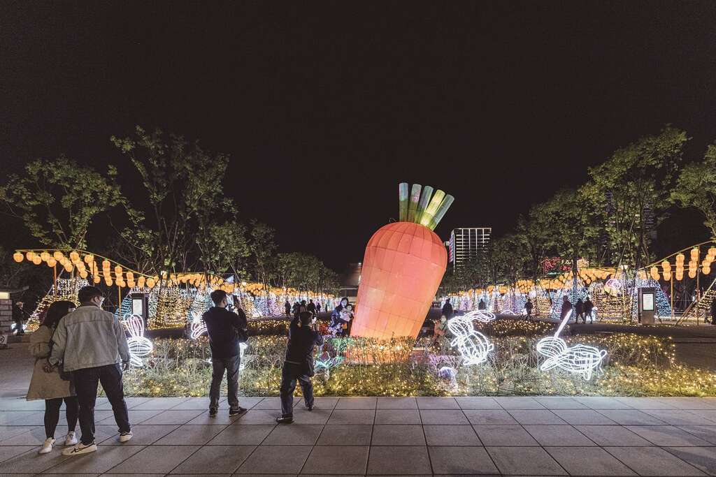 巨大的红萝卜造型花灯，不只吸引可爱的白兔围绕，也吸引民众上前拍照，为中央展区增添活泼、趣味的氛围。（摄影／林冠良）