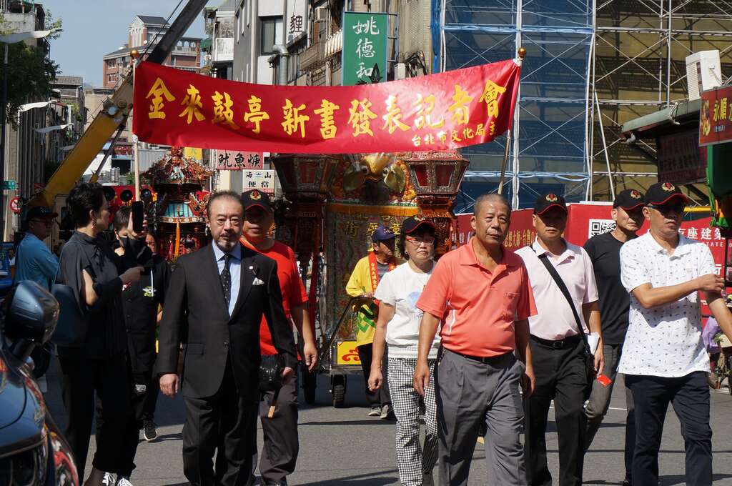 在台北共乐轩民艺文化协会理事长王崑文(图右)及轩社元老头人蔡金涂先生公子蔡桂良带领下，共乐轩及金来鼓亭两乐团子弟一起遶境宣传新书发表(图片来源：台北市政府文化局)