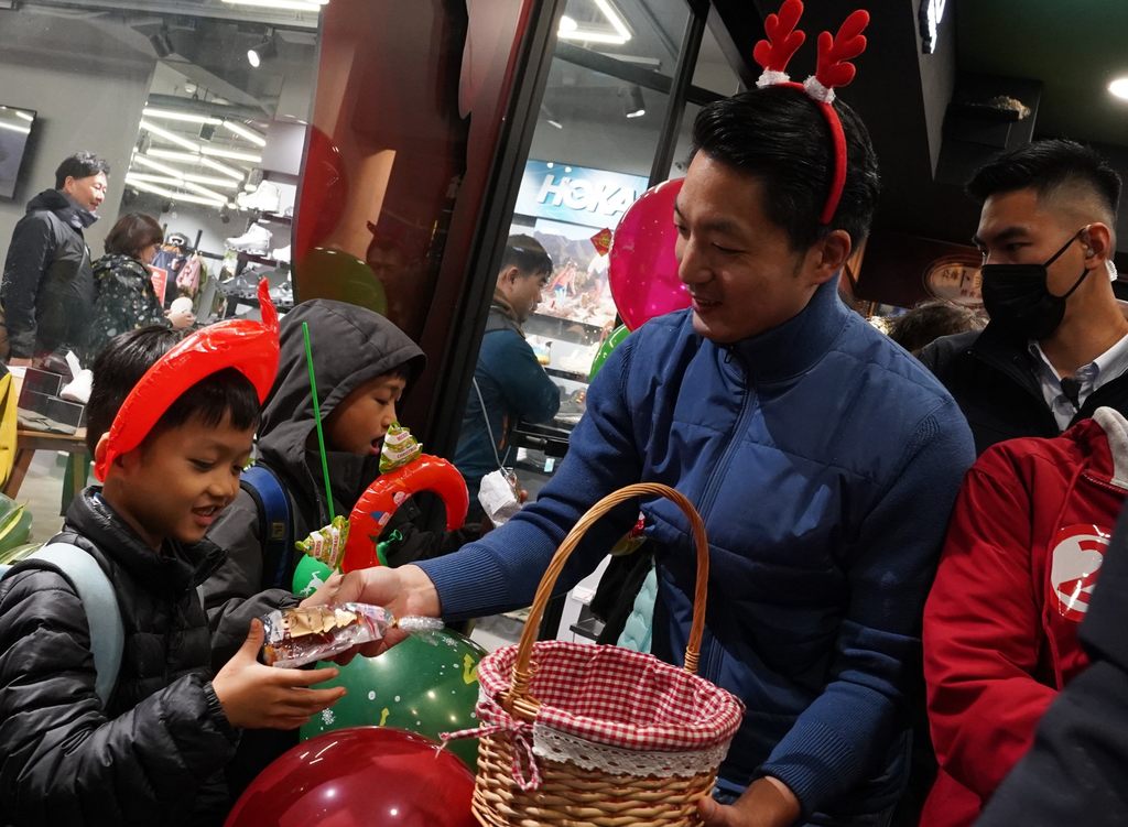 蔣市長與健走隊伍沿路發放耶誕禮物予小朋友。(圖片來源：臺北市政府觀光傳播局)