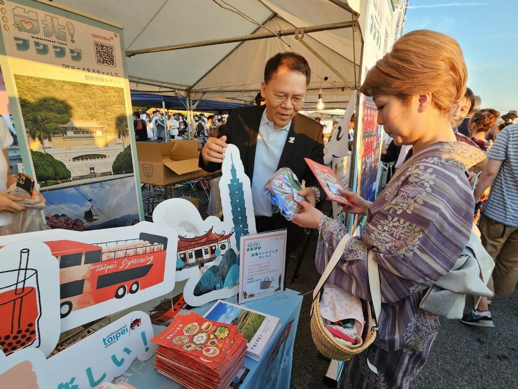 北市府观传局长王秋冬在「松山港祭・三津滨花火大会」台北摊位向日本民众推荐台北观光(图片来源：台北市政府观光传播局)
