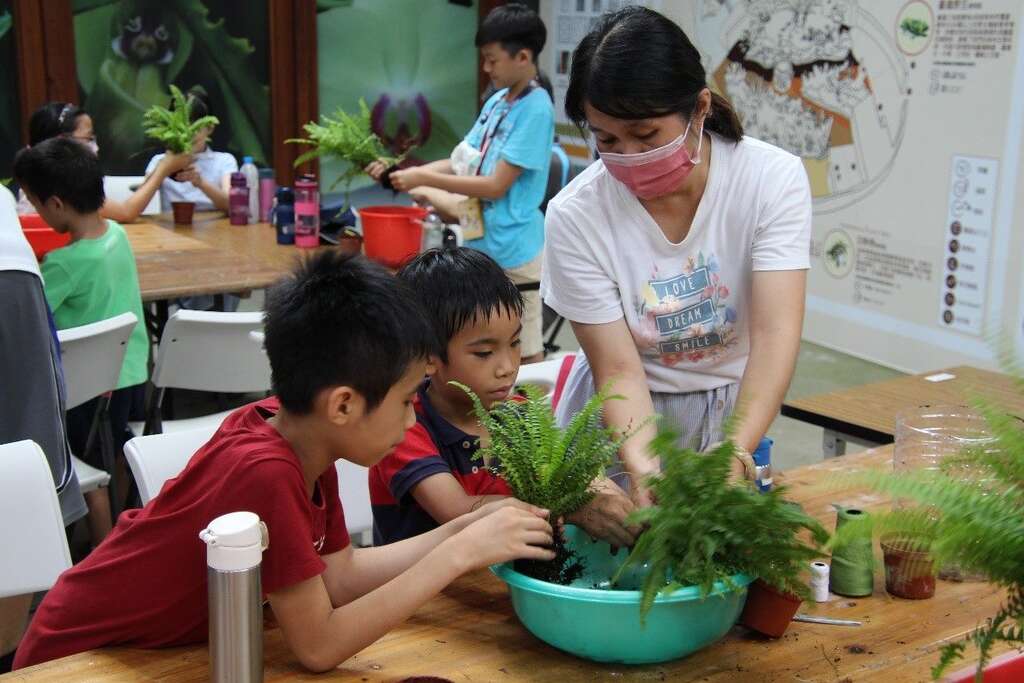 非常認真學習捏水苔球的方法。(圖片來源：臺北市政府工務局公園路燈工程管理處)