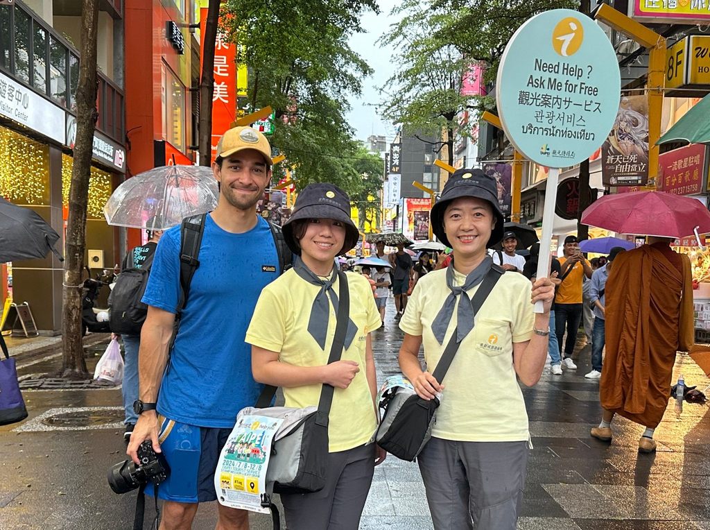 Wil Dasovich於西门町街区向走动式旅服人员谘询周边资讯(图片来源：台北市政府观光传播局)