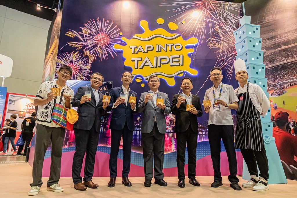2024马来西亚国际旅游展(MATTA FAIR)台北馆开幕，台北市秘书长李泰兴(中)、观传局长王秋冬(右三)与马来西亚旅游总会总会长王振添(左三)、出境部副会长张耀权(右二)，以及吉隆坡办事处主任周士弼一起体验珍珠奶茶、玉兔造型香氛蜡烛。(图片来源：台北市政府观光传播局)