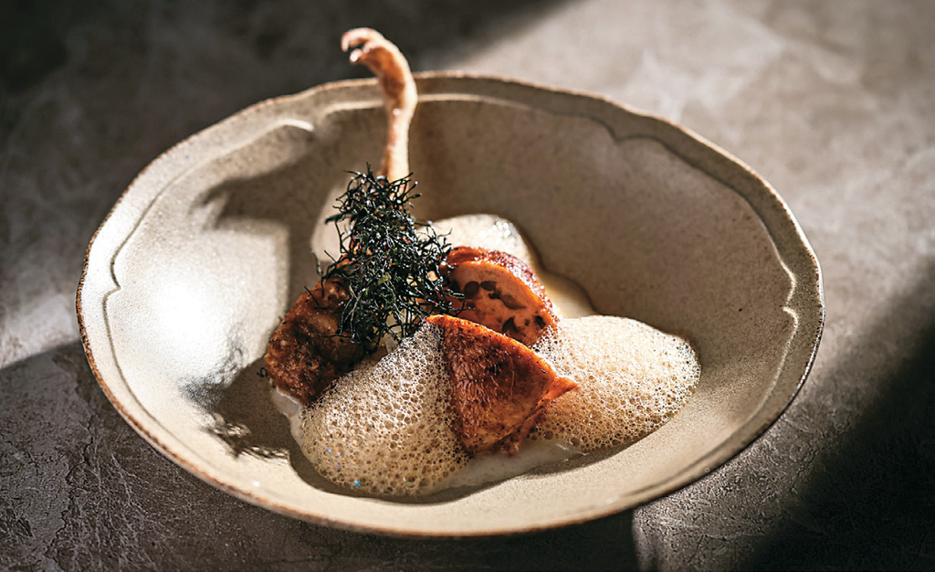 「Wok by O’BOND」的「昏鴉」選用嘉義鵪鶉肉填入紅豆及牛肝菌等餡料，再以烤、炸方式處理不同部位，創造出風味獨特的料理。（圖／Wok by O’BOND）