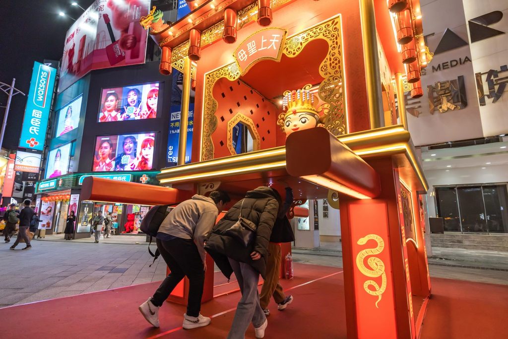 民众可以捷运西门6号出口的台北天后宫「钻轿脚」灯组下方钻过，祈求平安、消灾解厄，也同时体验这项台湾传统文化仪式。(图片来源：台北市政府观光传播局)