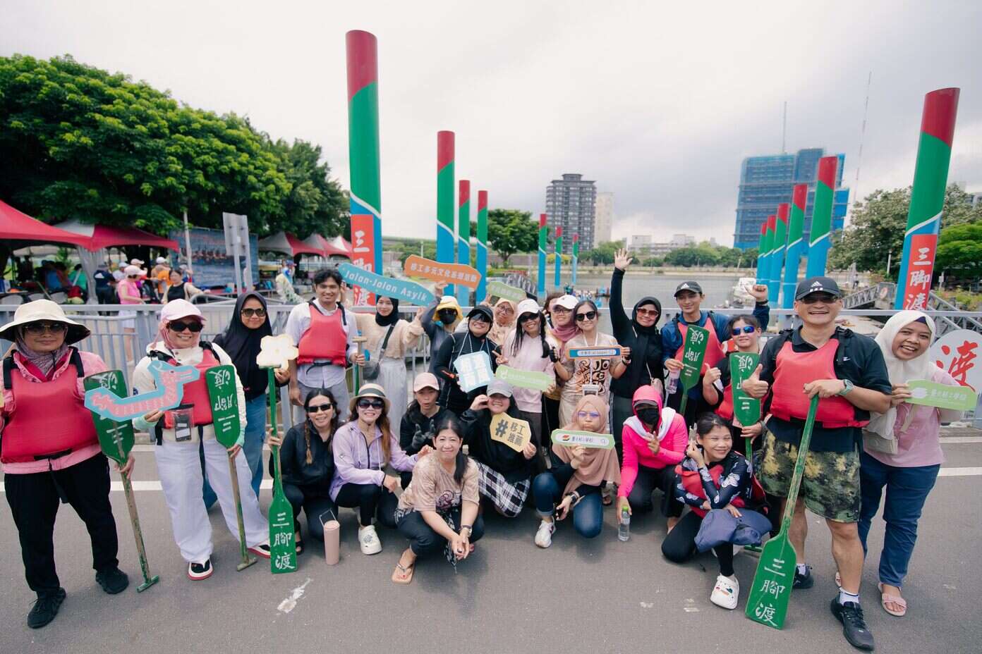 移工們個個開心的划完龍舟在岸上合影(圖片來源：臺北市政府勞動局)