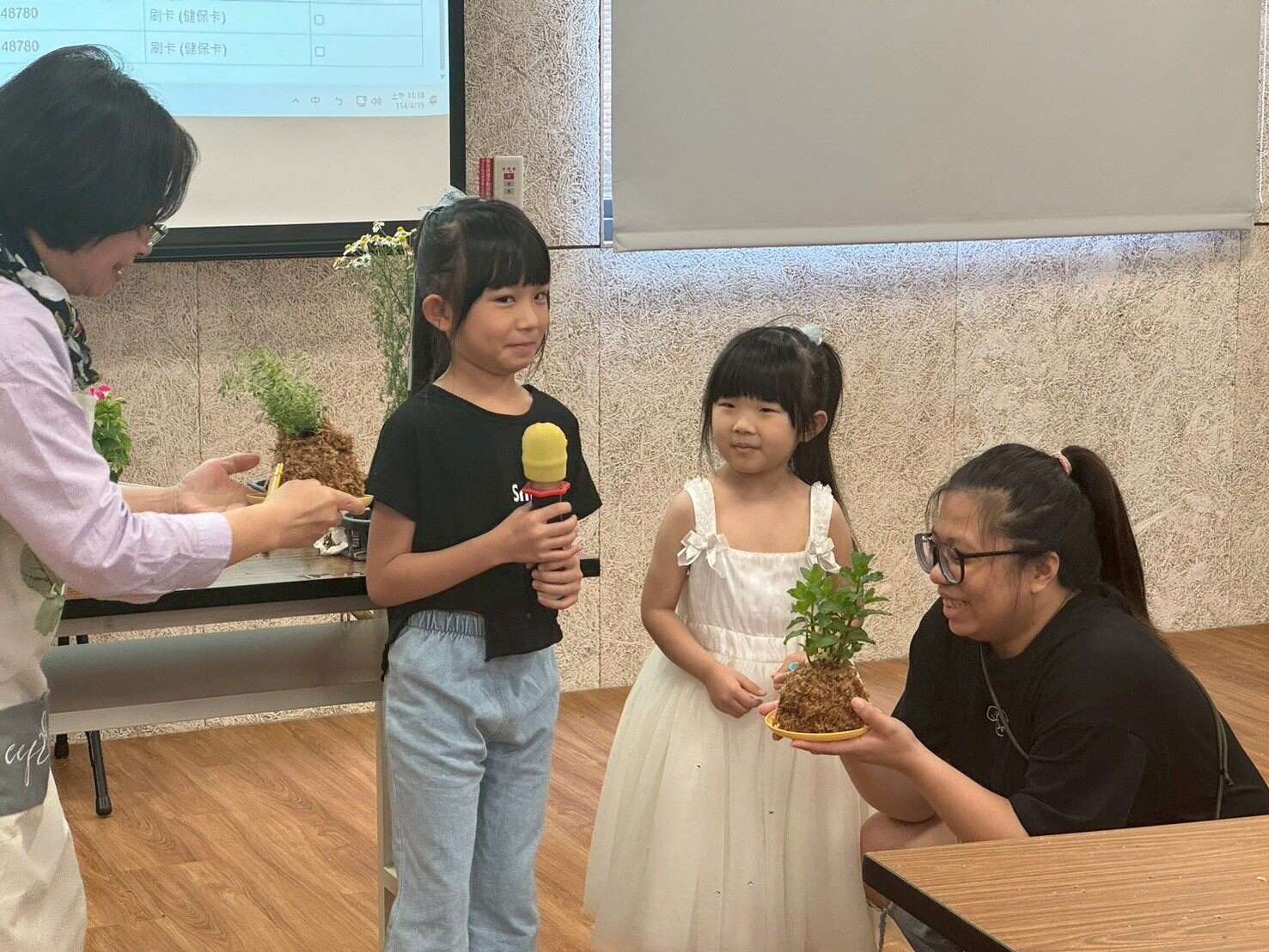 小朋友害羞地分享與家人一起完成的水苔球。