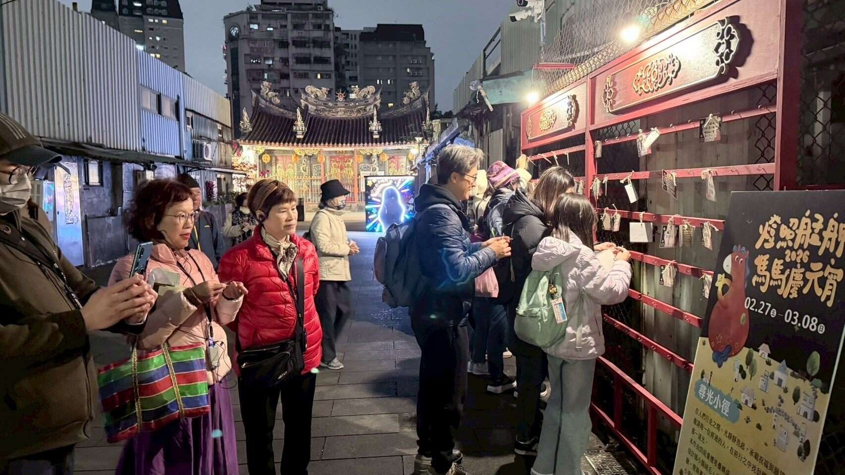 民眾在「燈照艋舺：馬馬慶元宵」活動許願牆綁上許願卡，祈求平安與心願成真。（圖片來源：臺北市政府觀光傳播局）