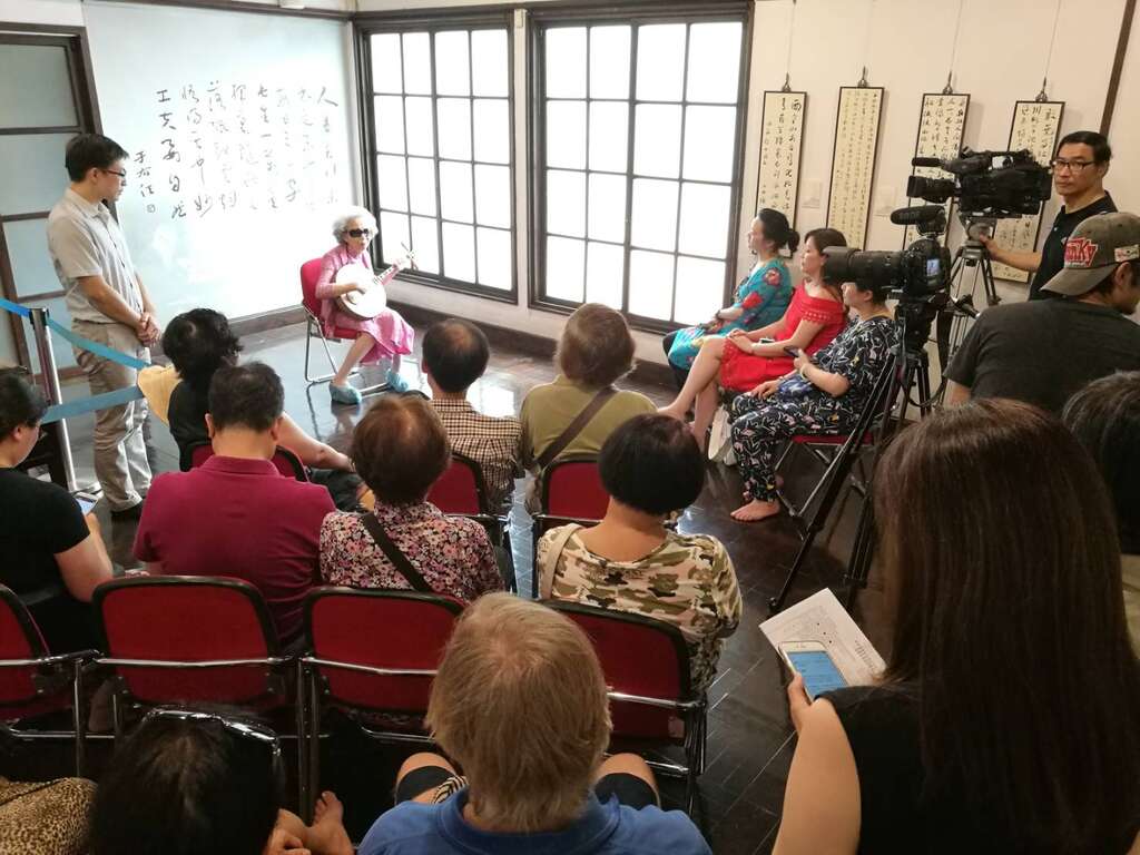 國寶級藝師楊秀卿在梅庭的月琴唸唱吸引遊客及媒體耹聽