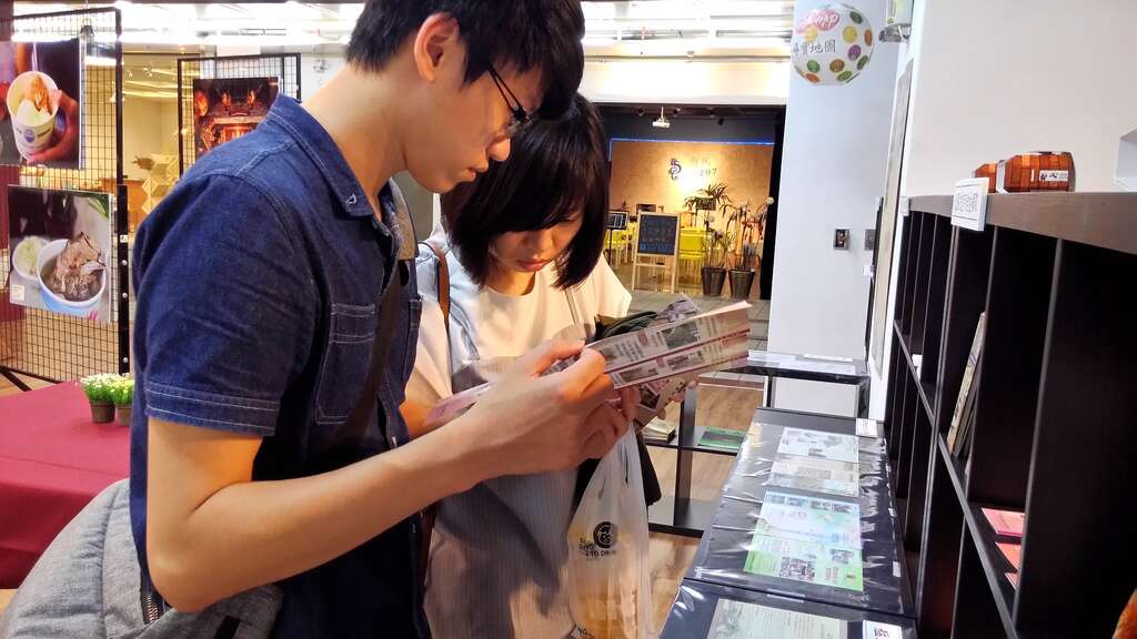 民眾於特展現場翻閱文宣品及旅遊導覽手冊
