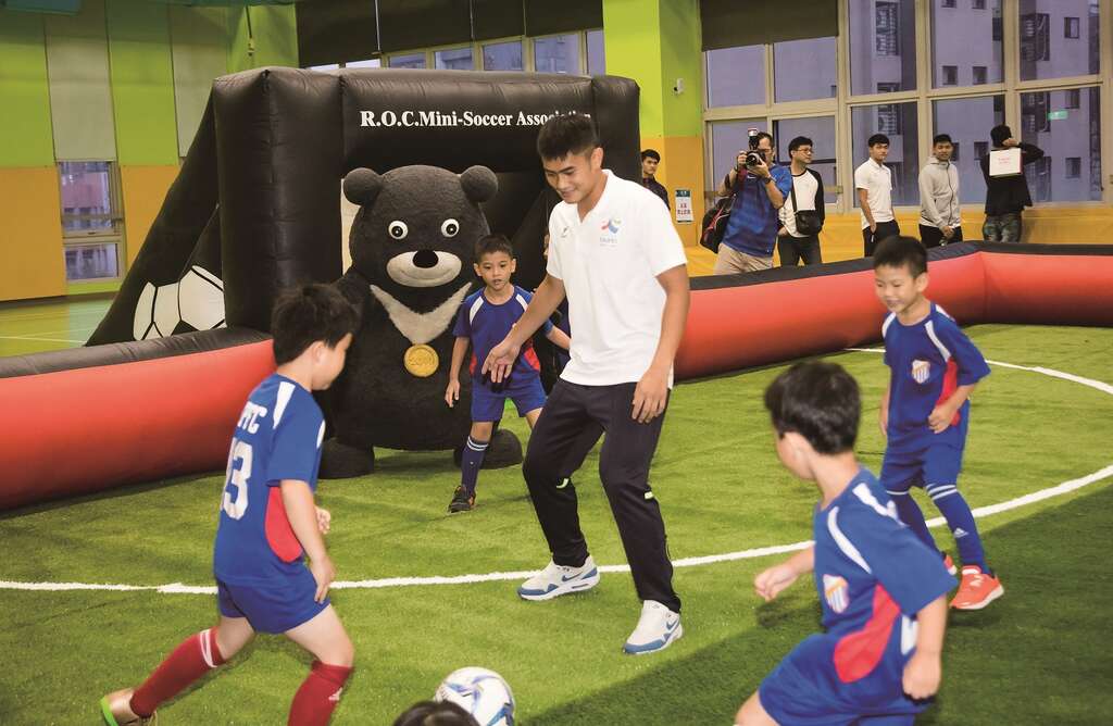 熊赞和世大运足球选手并肩作战，对抗活力十足的小足球员。