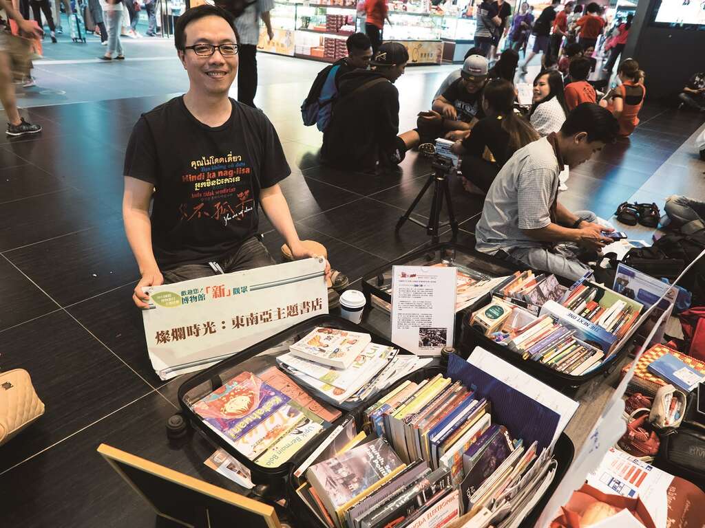燦爛時光發起人張正在台北車站大廳開設地板圖書館，希望為東南亞移工提供一絲溫暖的關懷。（攝影╱許斌）