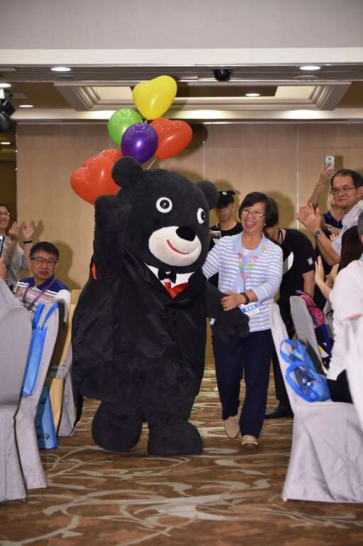 世大运执行长苏丽琼牵着燕尾服熊赞帅气登场，吸引现场所有目光！
