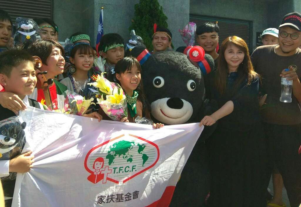 台北市政府观光传播局局长简余晏赠花及熊赞娃娃给南台北家扶中心的小朋友们，感谢参与花车游行
